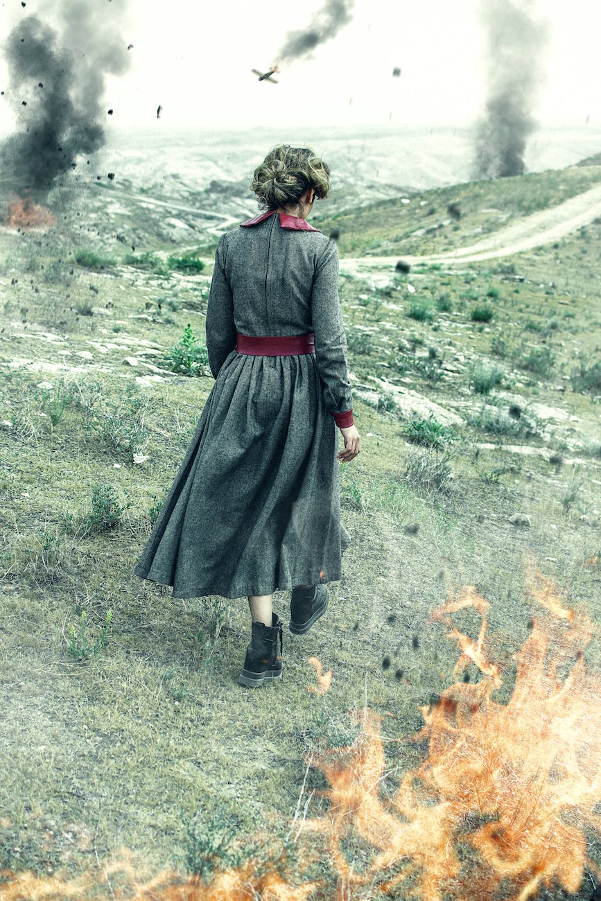 woman in a dress walking on a battlefield