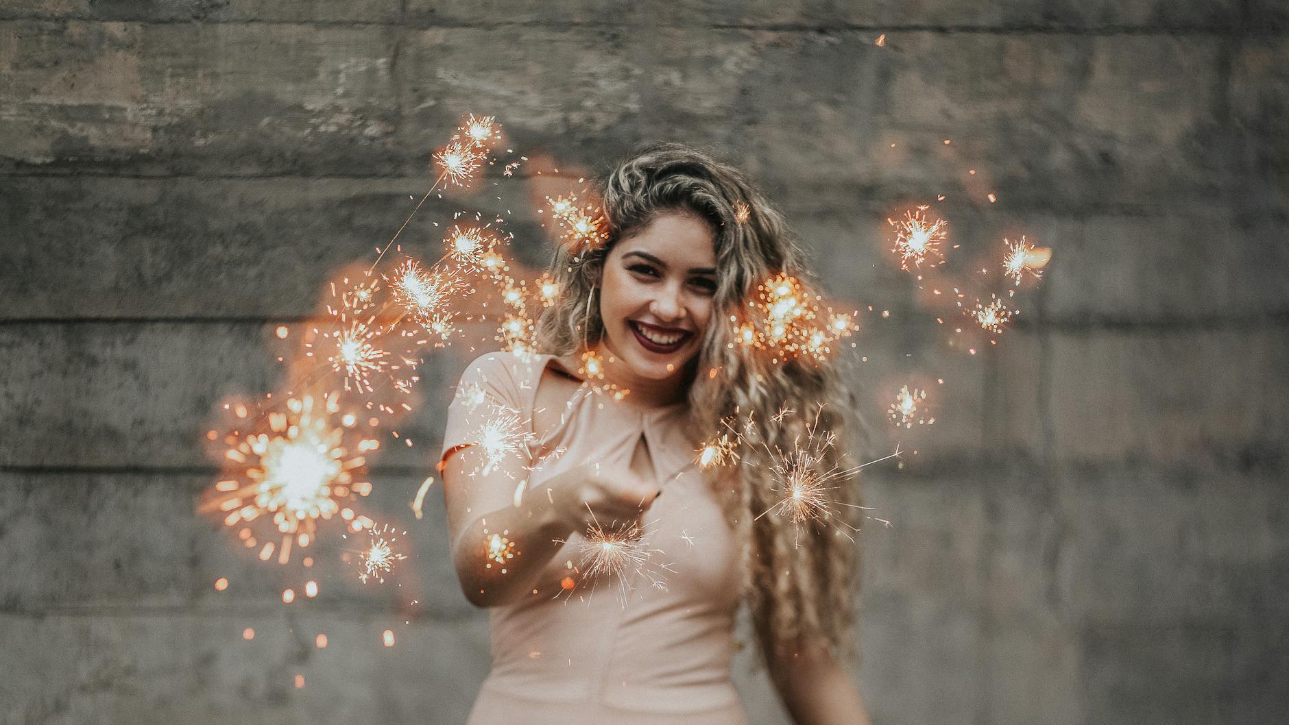 smiling woman holding sparklers