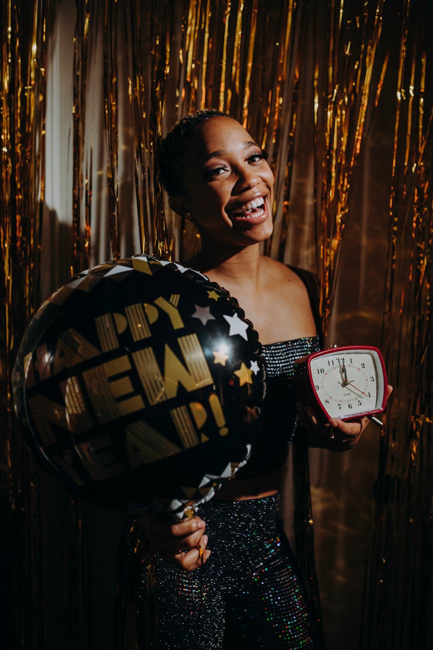 woman holding a balloon and an alarm clock